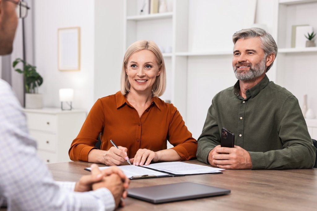 Couple smiling while reviewing documents with their accountant